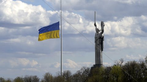 Aufnahme der Ukraine-Flagge an einem Fahnenmast neben der Mutter-Heimat-Statue in KyjiwKiew. (Foto: rbb/ARD/LOOKSfilm)
