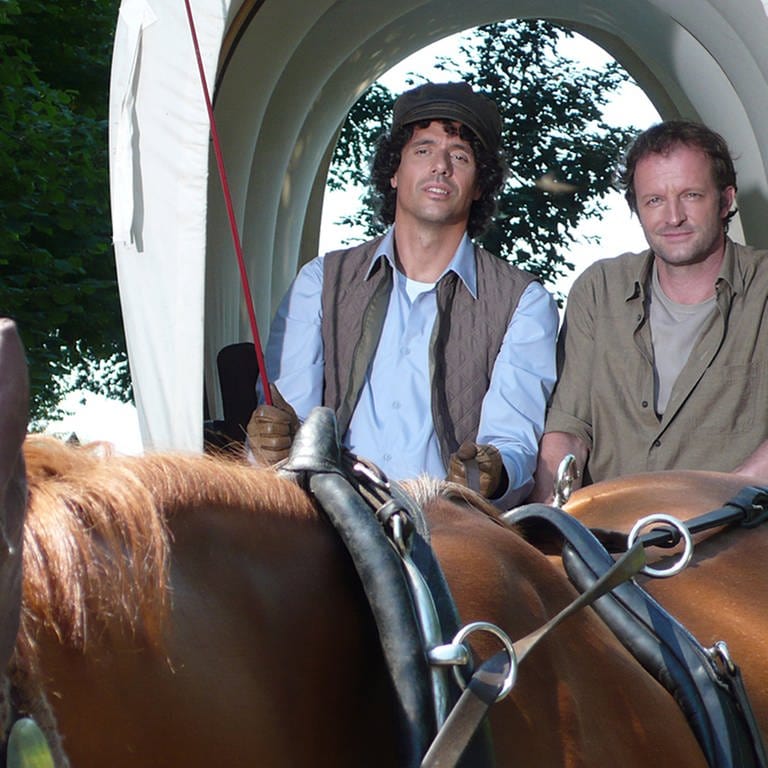 Matthias und Bernd fahren auf einem Planwagen, der von Pferden gezogen wird