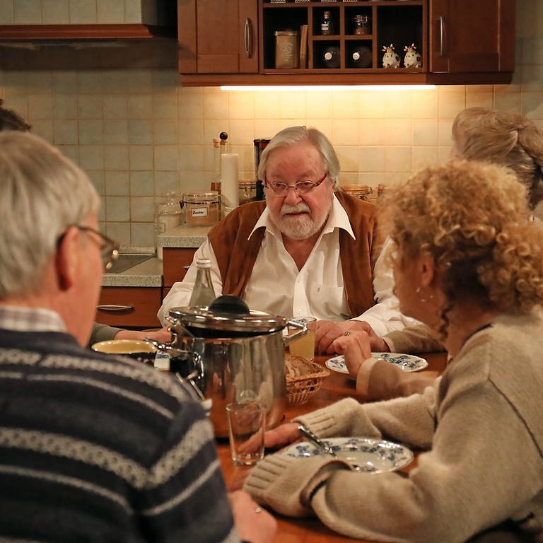 Hermann sitzt mit der Familie am Küchentisch