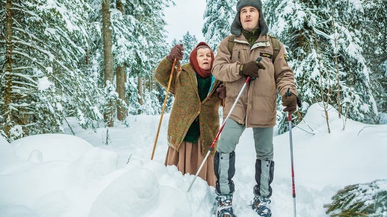 Sebastian und Lioba stapfen mit Schneeschuhen durch den verschneiten Wald