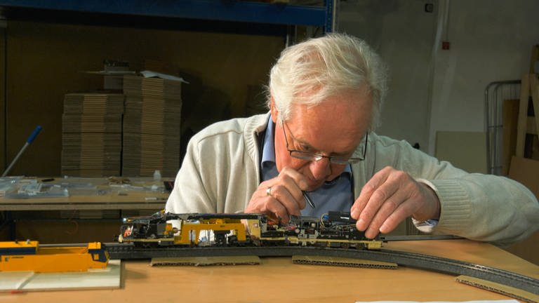 Der Chef persönlich, Wieland Viessmann, justiert das Testmodell der Unimat Schienenstopfmaschine. 