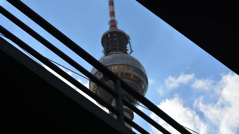 Der weltbekannte Berliner Fernsehturm am Alexanderplatz und vor ihm die Gleise des Bahnhofs Berlin Alexanderplatz.