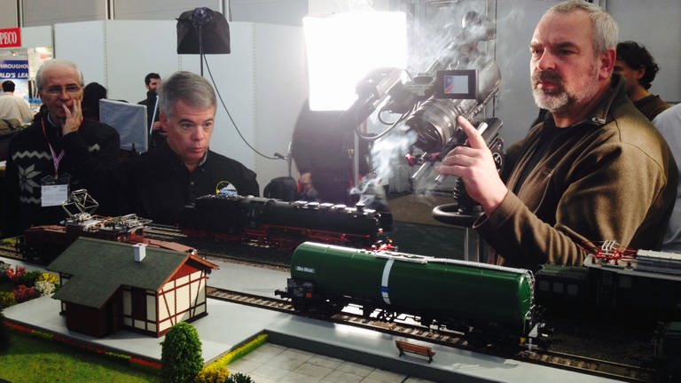 MTH: Mike Wolf, Chef der amerikanischen Modellbaufirma MTH, und Lok 44 339 unter Volldampf bei den Dreharbeiten für den Messefilm von Eisenbahn-Romantik