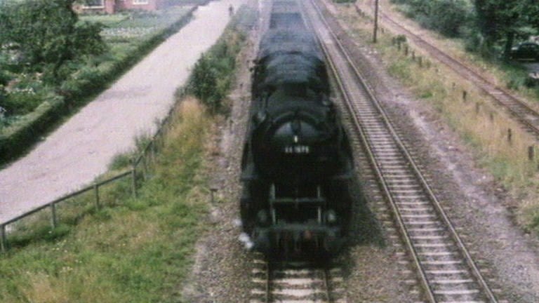 Ein Dampfzug der DB hat das Eisenerz im Hafen von Emden übernommen und bringt es zu den Hochöfen im Saarland.