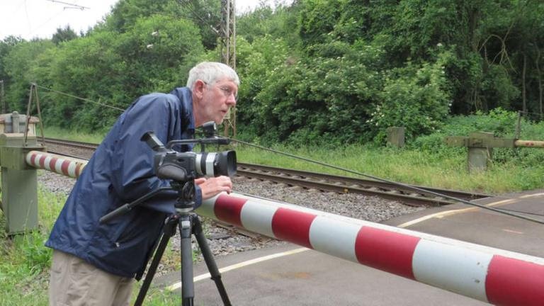 Profifilmer Peter Friesenhahn wartet an einem einsamen Bahnübergang in der Vordereifel auf interessante Züge