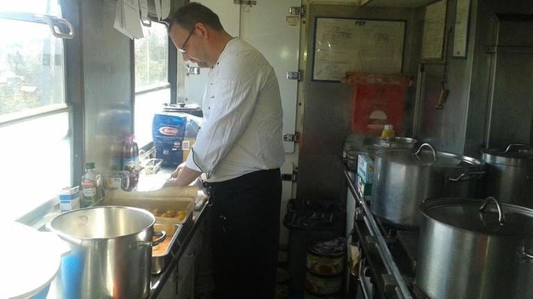 Koch Andres Rosenbusch bereitet in der beengten Küche das Mittagessen vor