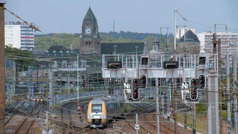 Die südliche Einfahrt in den Bahnhof Metz-Ville. Im Hintergrund sichtbar der Uhrenturm am Bahnhofsgebäude, sowie der Wasserturm, der für die Versorgung der Dampflokomotiven mit Wasser zuständig war.