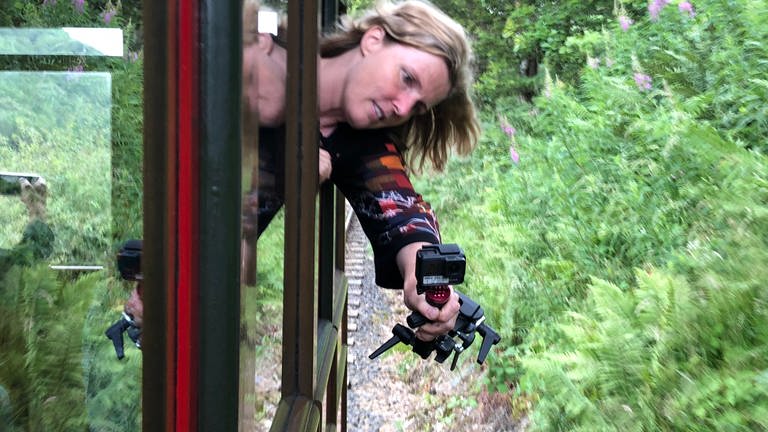 Die SWR-Redakteurin filmt Farne und Fingerhüte, an denen die Bahn entlangstreift. Die Talyllyn Railway bewegt sich durch eine zauberhafte Landschaft.
