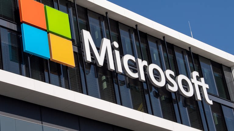 Das Microsoft Logo hängt an der Fassade eines Bürogebäudes