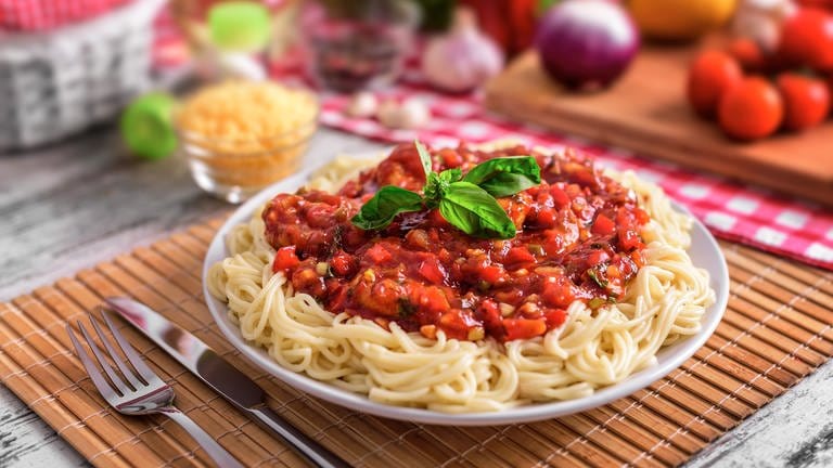 Teller mit Spaghetti Bolognese und Gemüse drum herum
