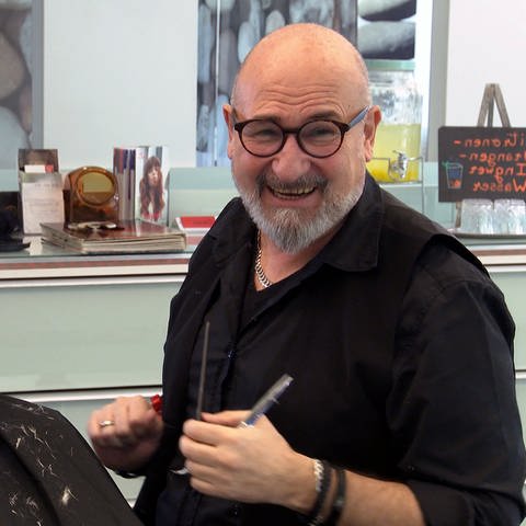 Friseur Roberto Laraia schneidet in seinem Friseursalon in Reutlingen einer Kundin die Haare