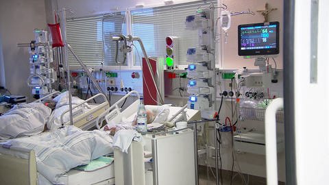 Intensivstation mit zwei Patienten in ihren Betten und vielen technischen Hilfsmitteln neben den Betten