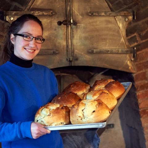 Frau präsentiert traditionelle Brot-Spezialitäten