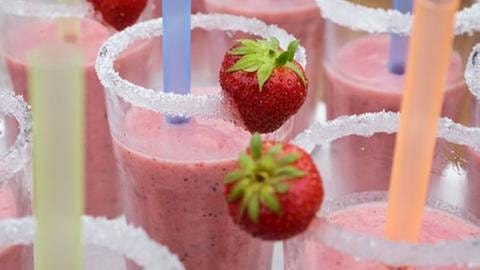 Erdbeer-Frappé im Glas mit Zuckerrand und zwei Erdbeeren