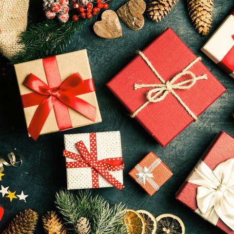 Verpackte Weihnachtsgeschenke liegen auf einer Platte. Welche Rechte haben Verbraucher, wenn sie Waren umtauschen wollen? Wie steht es um Gewährleistung und Garantie? Kann ich Geschenke zurückverlangen?