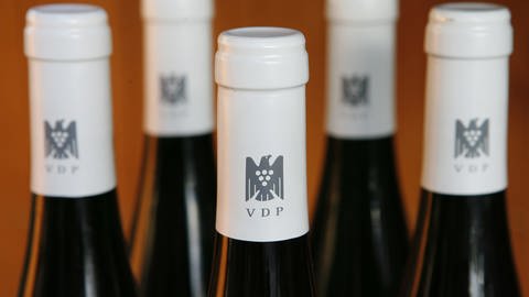 Das Emblem des Verbandes der Prädikatsweingüter (VDP), ein Adler mit Weintraube, ist auf den Kapseln von Weinflaschen des Kaiserstühler Prädikatsweingutes Dr. Heger in Ihringen aufgedruckt